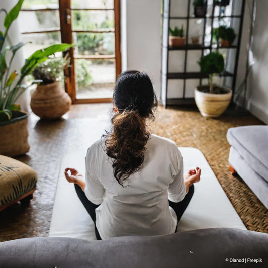 Frau meditiert zu Hause