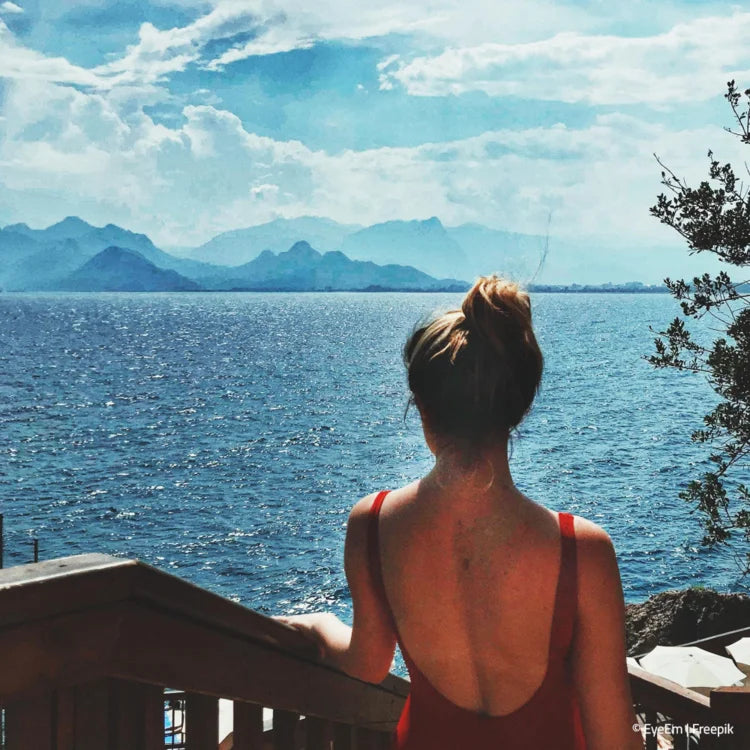 Frau sieht vom Hotel aus auf den See