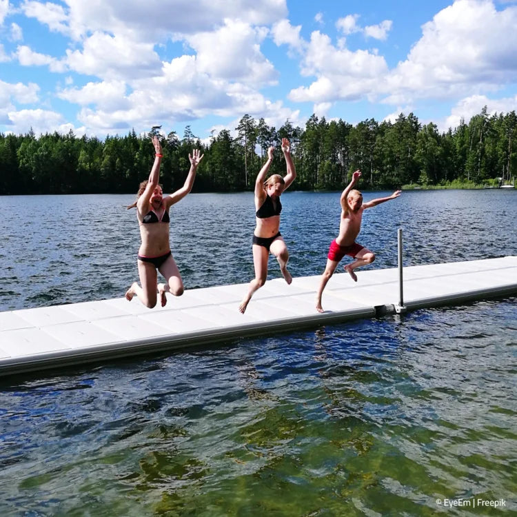 Kinder hüpfen vom Landesteg in den See