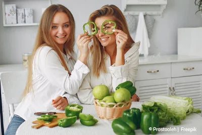 Zwei Frauen genießen gesunde Lebensmittel und planen gemeinsam ihren Abnehmurlaub in Deutschland