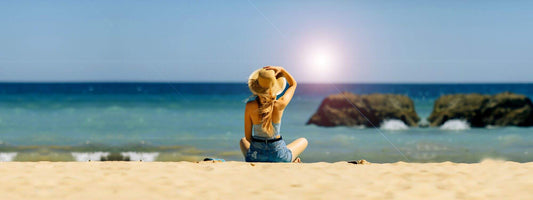 Frau mit Hut am Strand