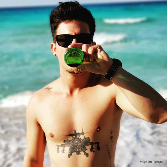 Mann am Strand trinkt Bier