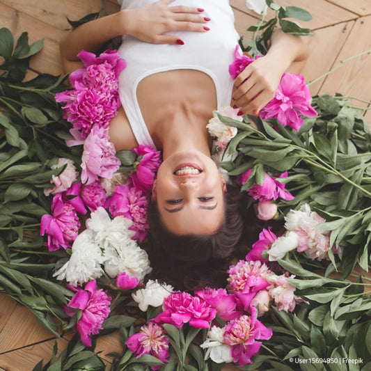 Frau  liegt am Boden im Blumenbeet