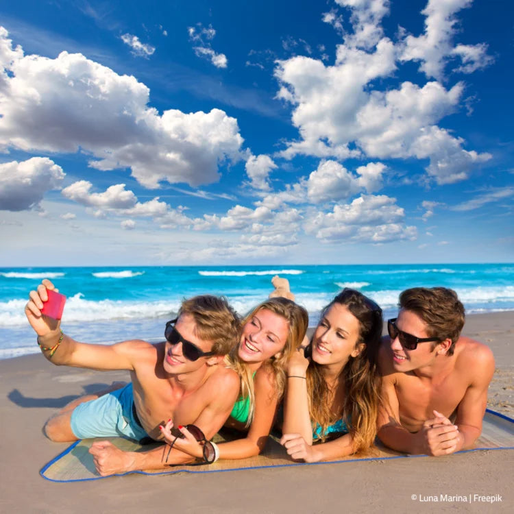 2 Pärchen liegen am Strand