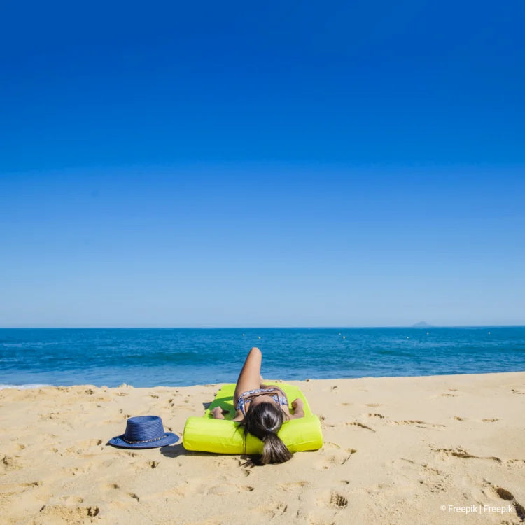 Frau liegt am Strand