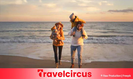 Familie mit 2 Kinder albern am Strand