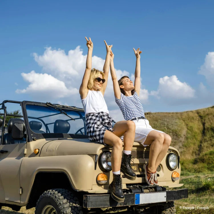 2 Frauen auf der Motorhaube eines geländewagens