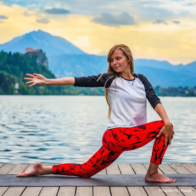 Frau macht Yoga am Landungssteges eines Sees