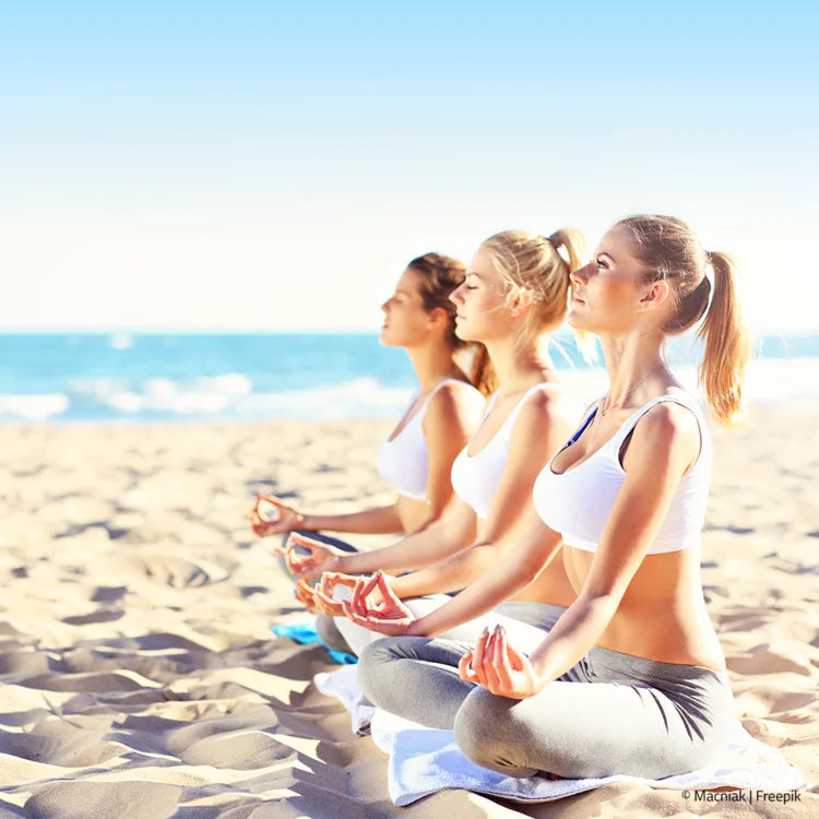 Frauen macht Yoga am Strand