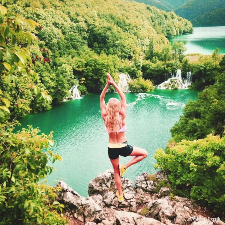 Frau macht Yoga am Felsen